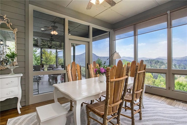 sunroom / solarium featuring a mountain view and wood finished floors