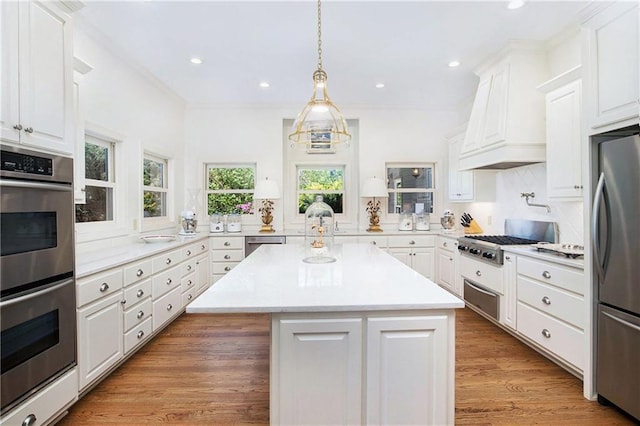 kitchen featuring stainless steel appliances, light countertops, a warming drawer, white cabinetry, and recessed lighting