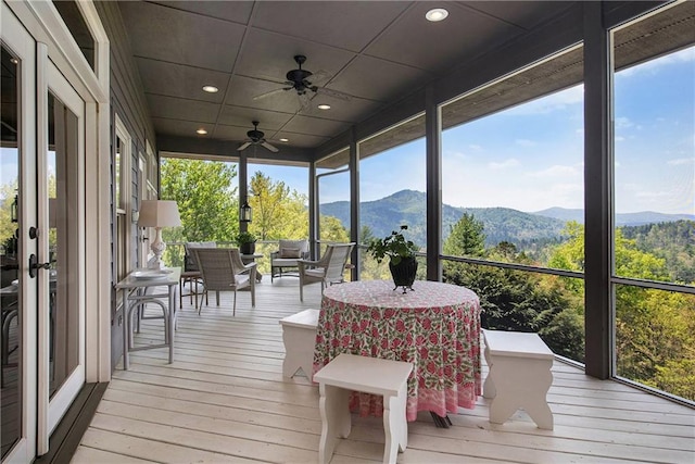 sunroom / solarium with a mountain view, ceiling fan, and outdoor lounge area