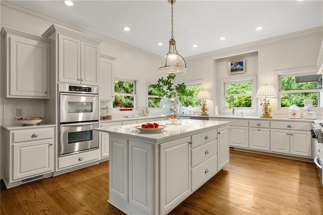 295 Goble Gap Ln, Clayton, GA 30525 - kitchen with double oven, light countertops, a kitchen island, tasteful backsplash, and crown molding
