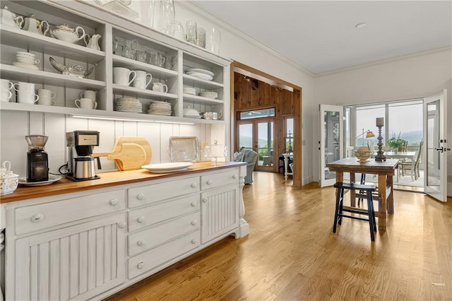295 Goble Gap Ln, Clayton, GA 30525 - kitchen with crown molding, open shelves, white cabinetry, and light wood-type flooring