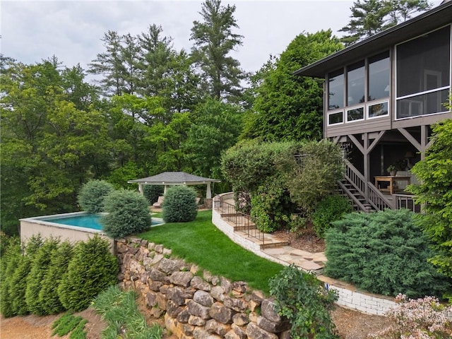 view of yard with a gazebo, an outdoor pool, and a sunroom