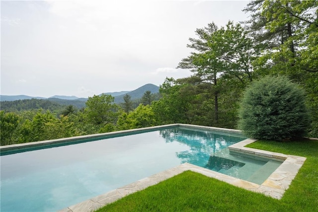 swimming pool featuring a mountain view and a view of trees