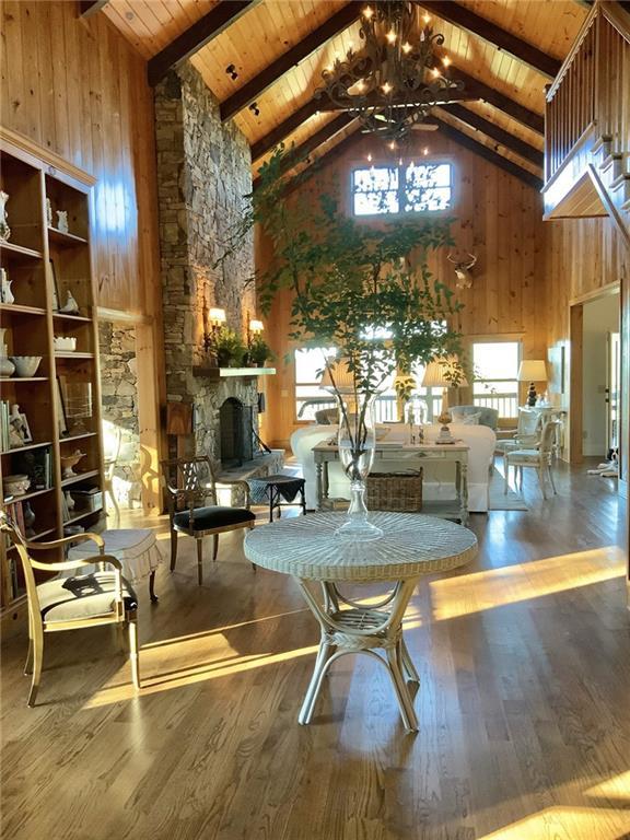 common area featuring high vaulted ceiling, wooden ceiling with exposed beams, and wooden walls