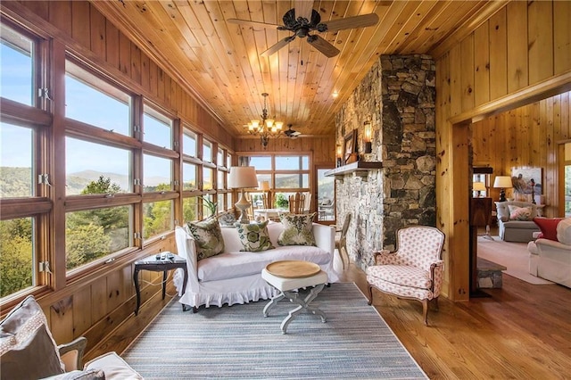 sunroom featuring wooden ceiling, wooden walls, wood finished floors, and a chandelier