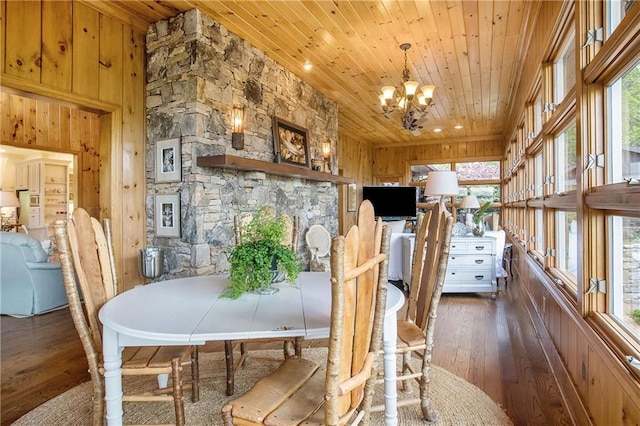 dining space featuring wood ceiling, hardwood / wood-style floors, wood walls, a chandelier, and healthy amount of natural light