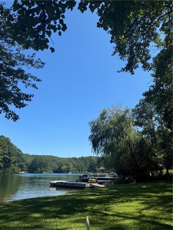 view of home's community with a water view and a yard