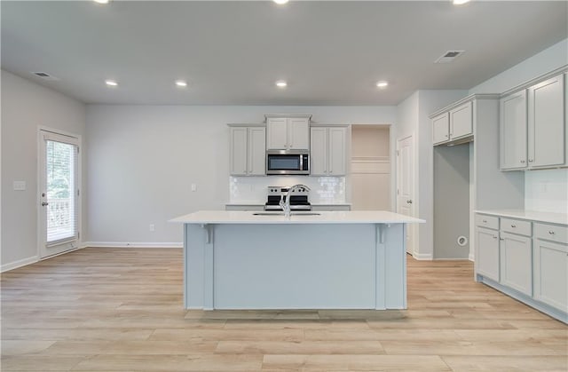 20 Fayme Ct, Newnan, GA 30263 - kitchen featuring appliances with stainless steel finishes, light countertops, light wood finished floors, decorative backsplash, and recessed lighting