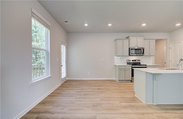 20 Fayme Ct, Newnan, GA 30263 - kitchen with stainless steel appliances, a sink, recessed lighting, light wood-style flooring, and light countertops