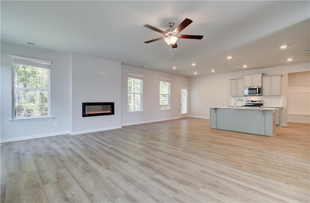 20 Fayme Ct, Newnan, GA 30263 - unfurnished living room featuring plenty of natural light, recessed lighting, light wood-type flooring, and ceiling fan