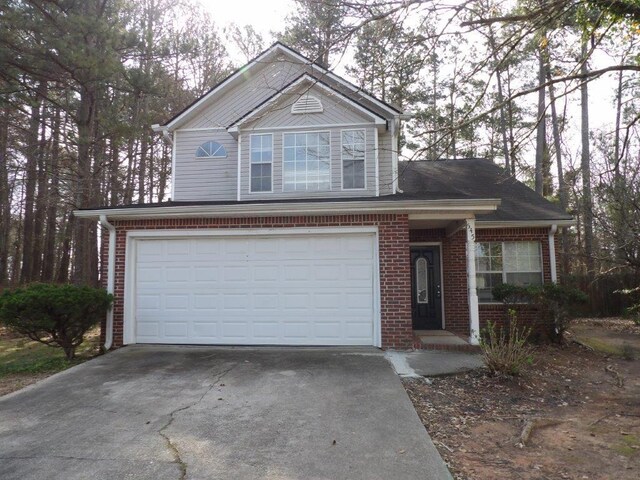 view of front of property with a garage, brick siding, and driveway