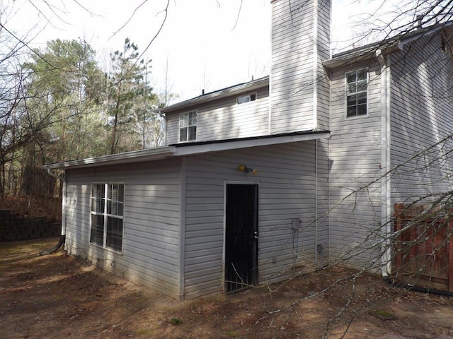 back of house featuring a chimney