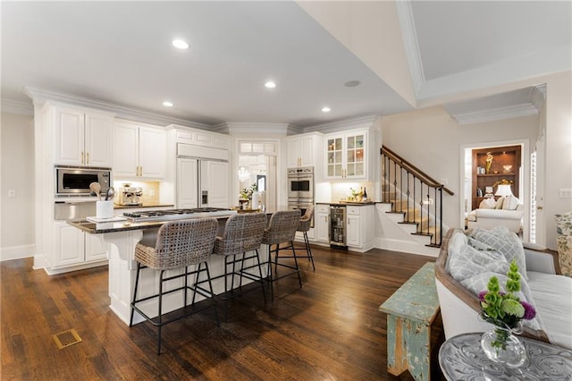 4789 Crest Park Ln, Marietta, GA 30068 - kitchen with wine cooler, stainless steel appliances, crown molding, a breakfast bar area, and recessed lighting