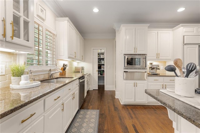 4789 Crest Park Ln, Marietta, GA 30068 - kitchen featuring stainless steel appliances, a warming drawer, white cabinetry, crown molding, and light stone counters