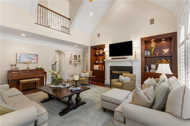 4789 Crest Park Ln, Marietta, GA 30068 - living room featuring arched walkways, high vaulted ceiling, a glass covered fireplace, ornamental molding, and recessed lighting