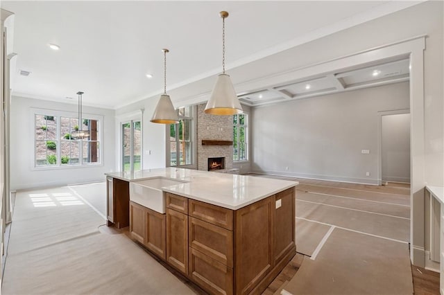 12 Night Fire Ct, Dawsonville, GA 30534 - kitchen with open floor plan, brown cabinetry, an island with sink, baseboards, and a fireplace