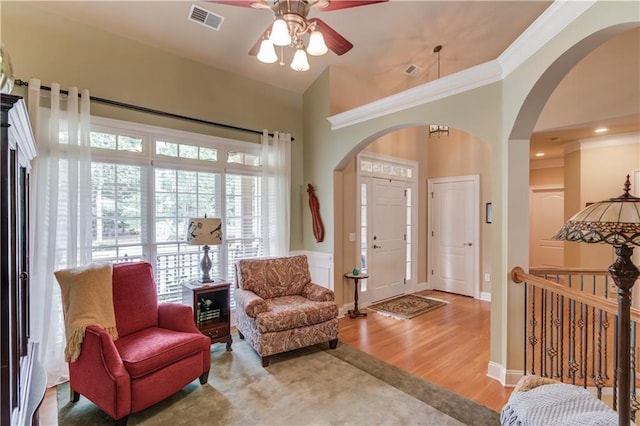 foyer entrance featuring crown molding, visible vents, and wood finished floors