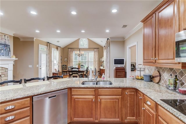 kitchen featuring open floor plan, a peninsula, appliances with stainless steel finishes, and a sink