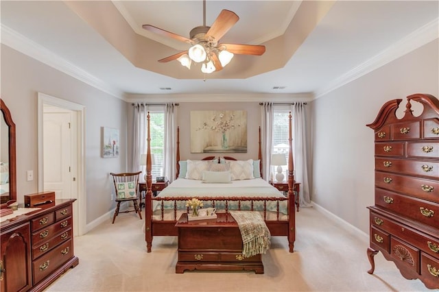 bedroom with a raised ceiling, light carpet, and baseboards