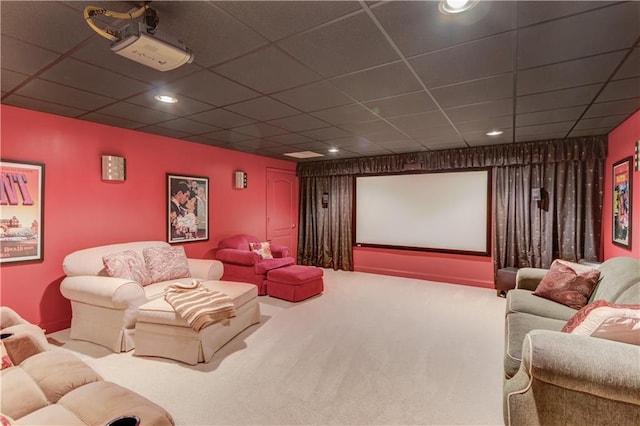 carpeted home theater with a drop ceiling and recessed lighting