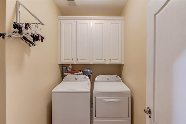 laundry area with visible vents, cabinet space, and washer and dryer