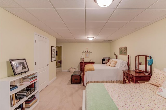 bedroom with carpet floors, a paneled ceiling, and baseboards