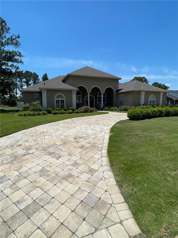 220 Pebble Beach Dr, Eufaula, AL 36027 - mediterranean / spanish house with stucco siding and a front lawn