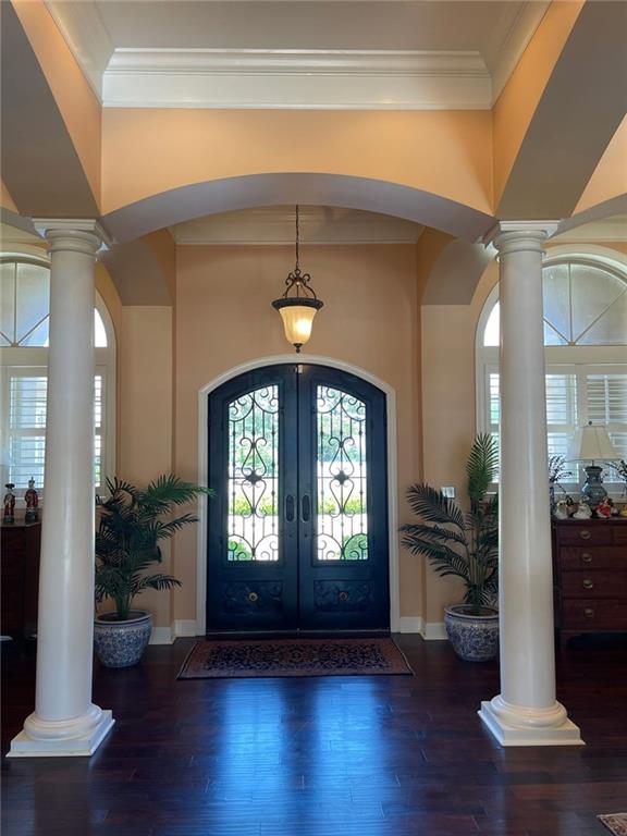 220 Pebble Beach Dr, Eufaula, AL 36027 - foyer featuring ornate columns, ornamental molding, french doors, arched walkways, and wood finished floors