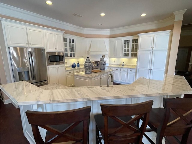 220 Pebble Beach Dr, Eufaula, AL 36027 - kitchen featuring appliances with stainless steel finishes, a large island, premium range hood, white cabinets, and crown molding