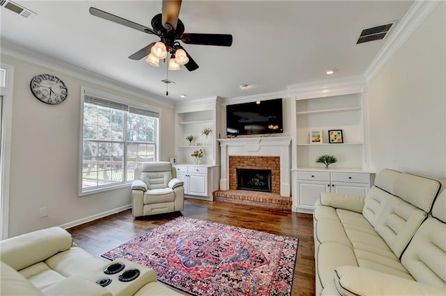 189 Azalea Chase Dr, Suwanee, GA 30024 - living room featuring crown molding, dark wood-type flooring, ceiling fan, a brick fireplace, and built in shelves