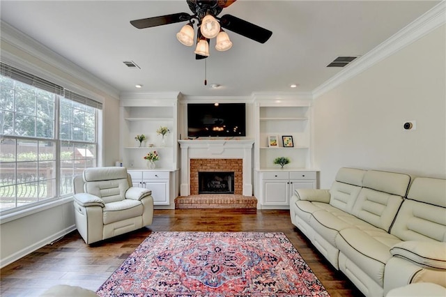 189 Azalea Chase Dr, Suwanee, GA 30024 - living area with crown molding, dark wood finished floors, a ceiling fan, a brick fireplace, and built in shelves