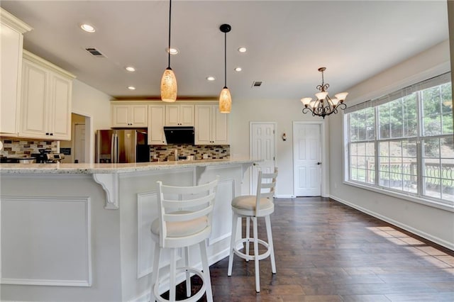 189 Azalea Chase Dr, Suwanee, GA 30024 - kitchen featuring stainless steel refrigerator with ice dispenser, recessed lighting, decorative backsplash, a breakfast bar, and hanging light fixtures