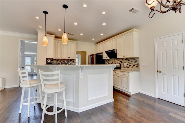 189 Azalea Chase Dr, Suwanee, GA 30024 - kitchen featuring freestanding refrigerator, backsplash, a kitchen breakfast bar, recessed lighting, and dark wood-type flooring