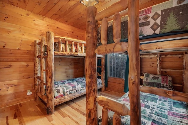 bedroom featuring wood ceiling, wood walls, and hardwood / wood-style floors