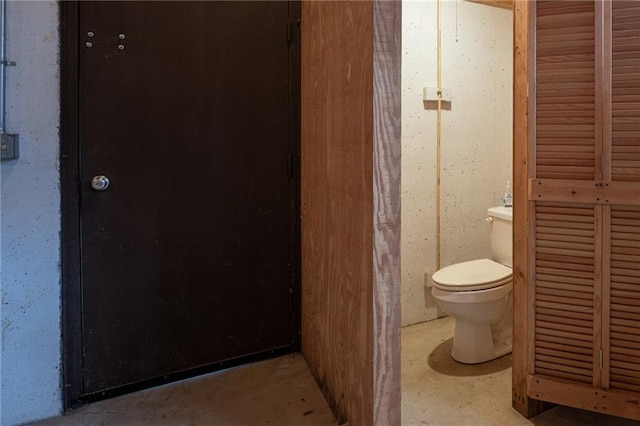 bathroom featuring concrete flooring and toilet