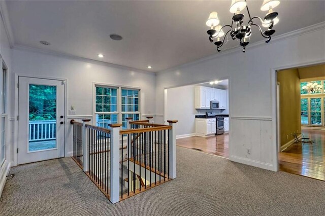 521 Crabapple Rd, Clarkesville, GA 30523 - hall with carpet, ornamental molding, an upstairs landing, a chandelier, and wainscoting