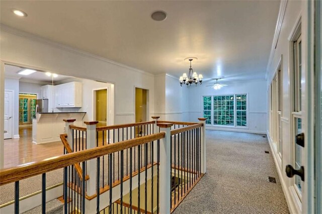 521 Crabapple Rd, Clarkesville, GA 30523 - hall with a chandelier, an upstairs landing, ornamental molding, a decorative wall, and light colored carpet