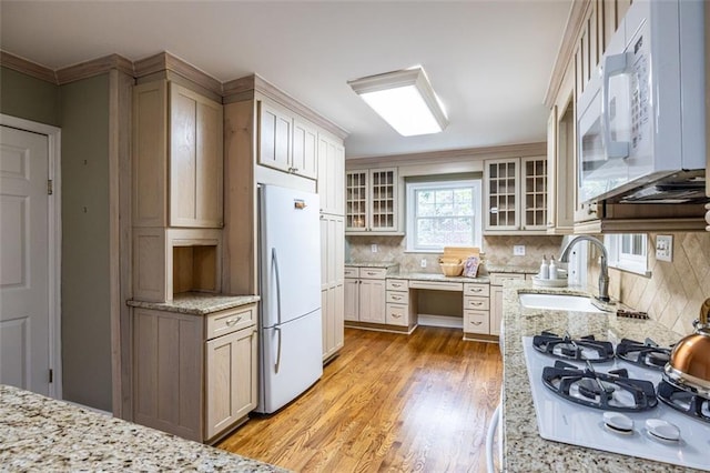 kitchen featuring white appliances, light wood-style flooring, decorative backsplash, and built in study area