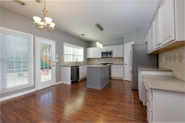 kitchen with a center island, visible vents, appliances with stainless steel finishes, dark wood-type flooring, and white cabinetry