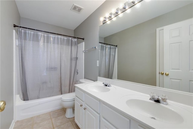 bathroom featuring toilet, visible vents, a sink, and tile patterned floors