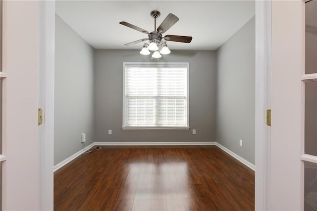 empty room with ceiling fan, baseboards, and wood finished floors