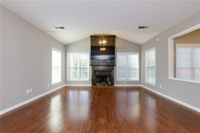 unfurnished living room featuring a chandelier, visible vents, a fireplace, and wood finished floors