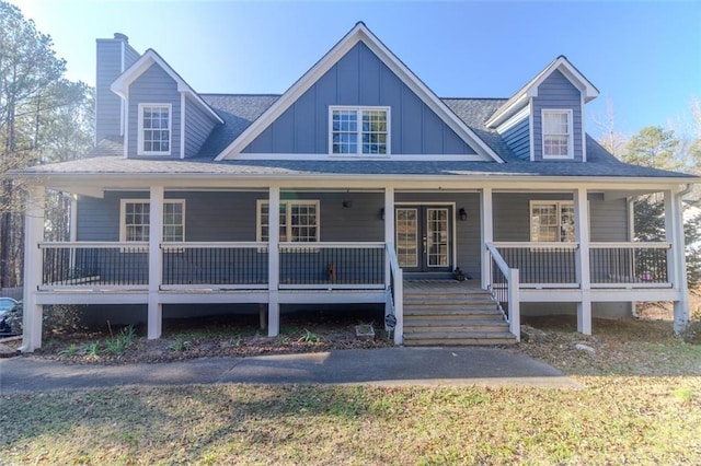 view of front of home with roof with shingles, a porch, board and batten siding, and french doors