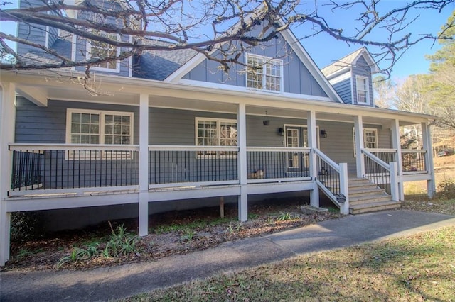 view of front of home with board and batten siding, covered porch, and a shingled roof