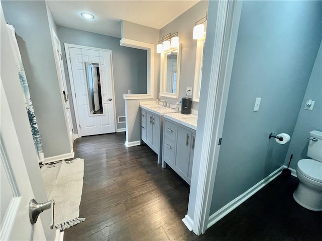 full bathroom with toilet, wood finished floors, visible vents, vanity, and baseboards