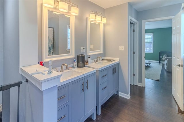 full bath with wood finished floors, vanity, and baseboards