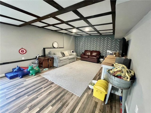 living room with wallpapered walls, baseboards, coffered ceiling, an accent wall, and wood finished floors