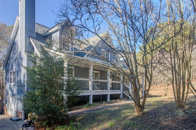 back of property with a garage and a porch