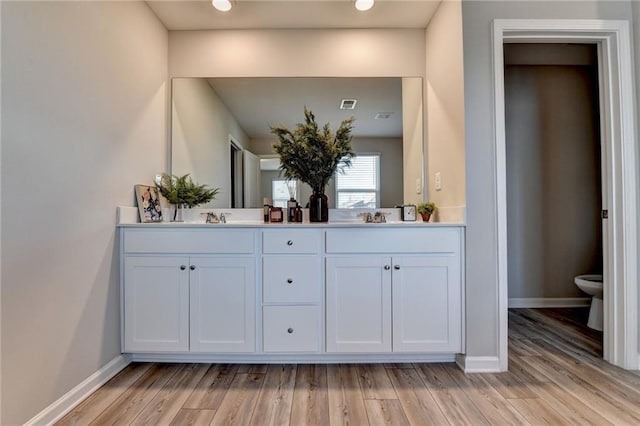 333 Golden Eagle Pkwy, Braselton, GA 30517 - full bath featuring baseboards, double vanity, wood finished floors, and toilet