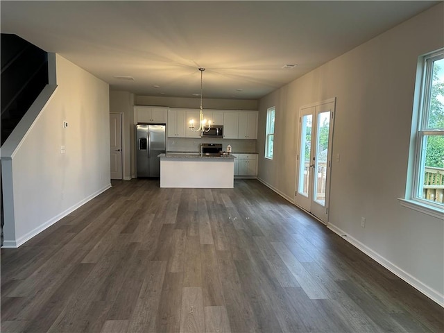 kitchen with appliances with stainless steel finishes, a healthy amount of sunlight, and decorative light fixtures